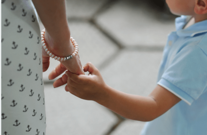 A person holding a child\'s hand.