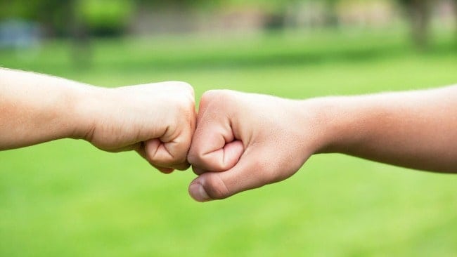 Two hands fist bumping.