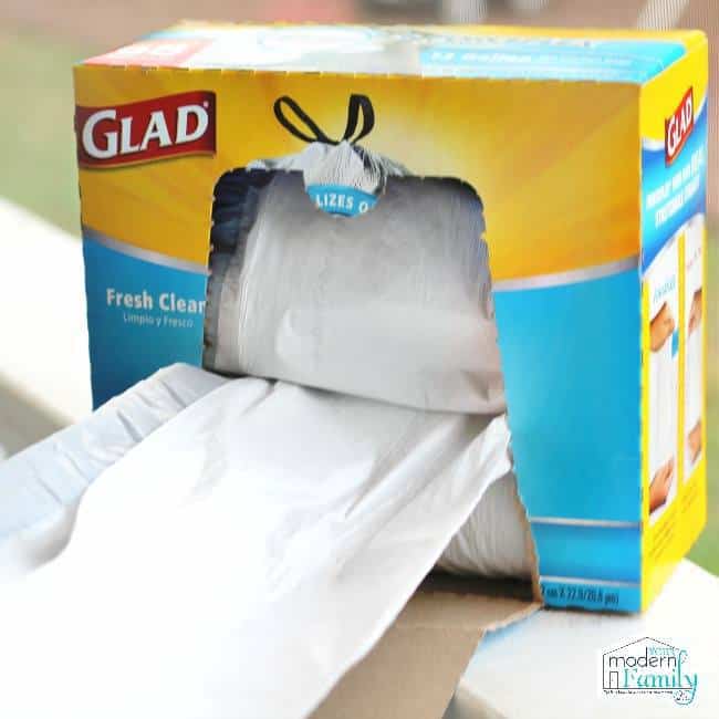 A close up of a box of Glad garbage bags with a bag being pulled out of the box.