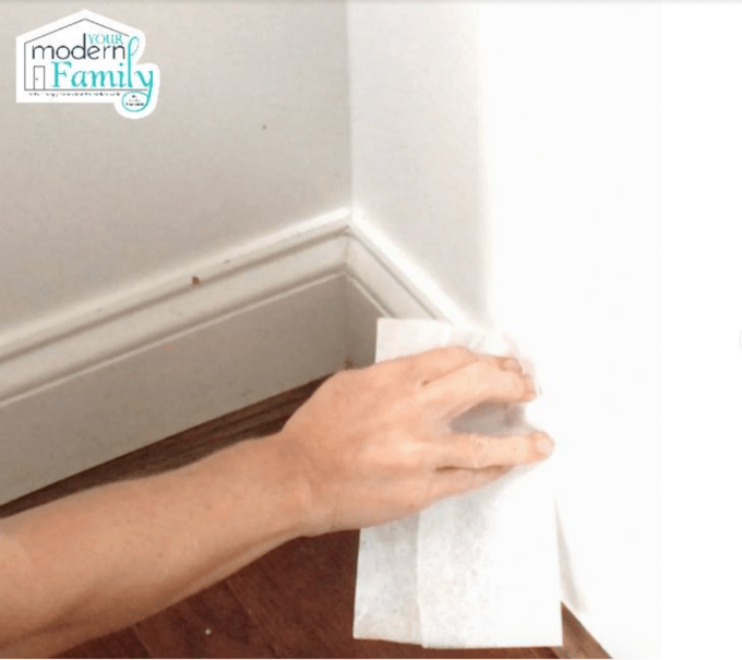 A person cleaning baseboards.