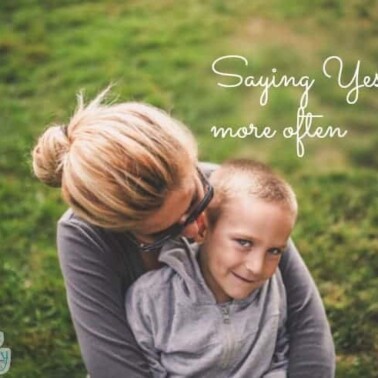 A woman holding a boy on her lap in the grass with text above them.
