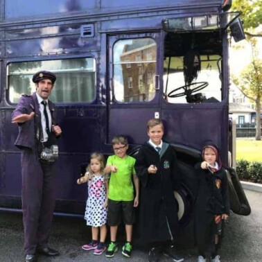 A group of people in costumes standing in front of a bus.