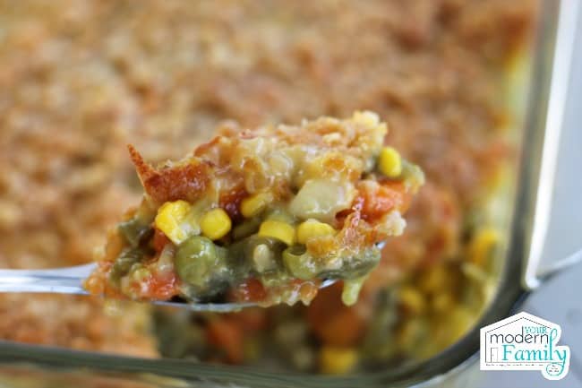A spoon full of Vegetable Casserole with Cheesy Cracker Topping.
