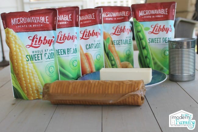 Libby\'s microwavable vegetables lined up behind a sleeve of crackers and a stick of butter.