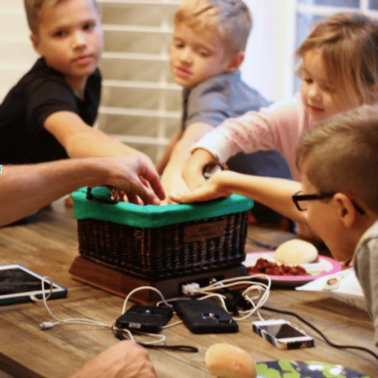 A group of people sitting at a table playing a game.