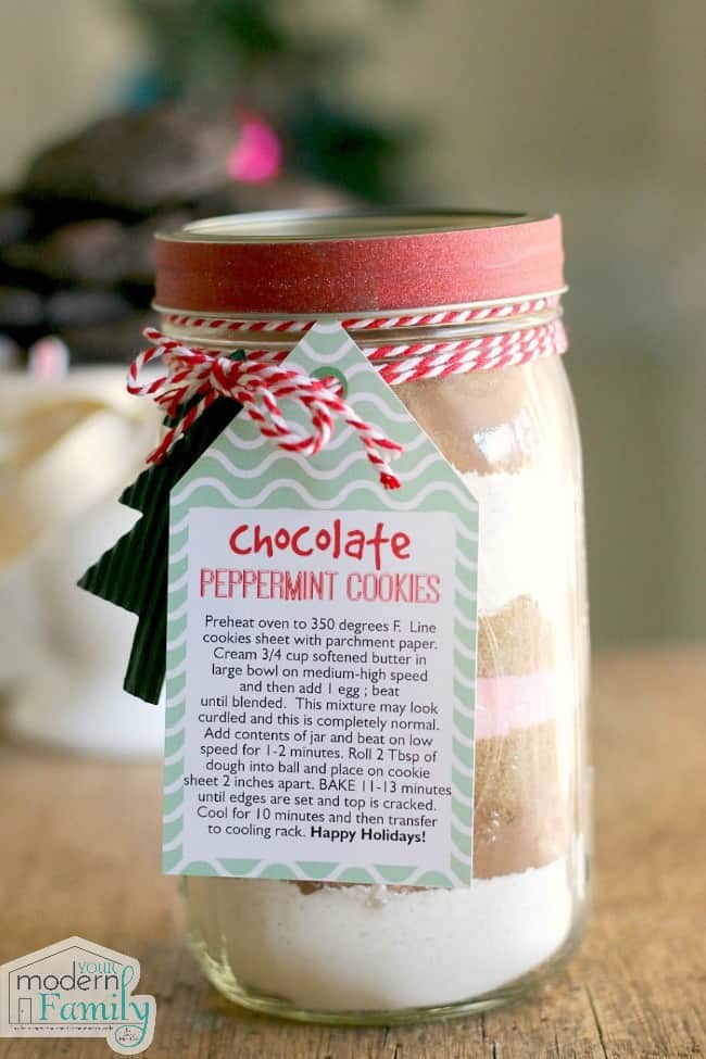 A close up of a jar with cookie ingredients and a recipe tag.