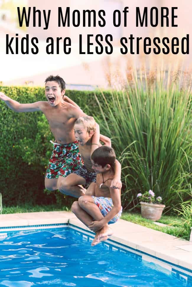 Three boys jumping in a pool of water.