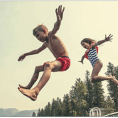 Two kids  jumping in the air.