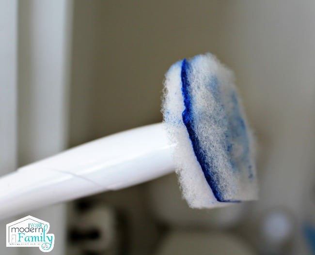 A close up of a blue toilet brush.