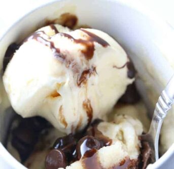 A bowl of dessert in a bowl with Cake and Chocolate syrup.
