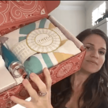 A person taking a selfie holding a FabFun box with items in it.