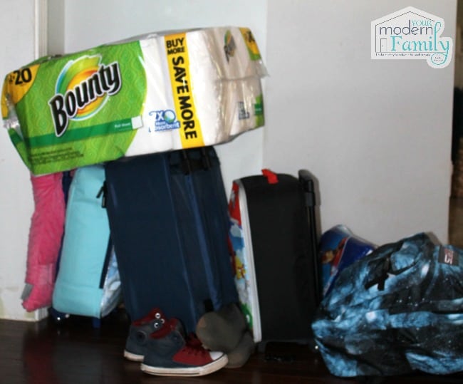 A pile of suitcases with a package of Bounty paper towels resting on top of them.