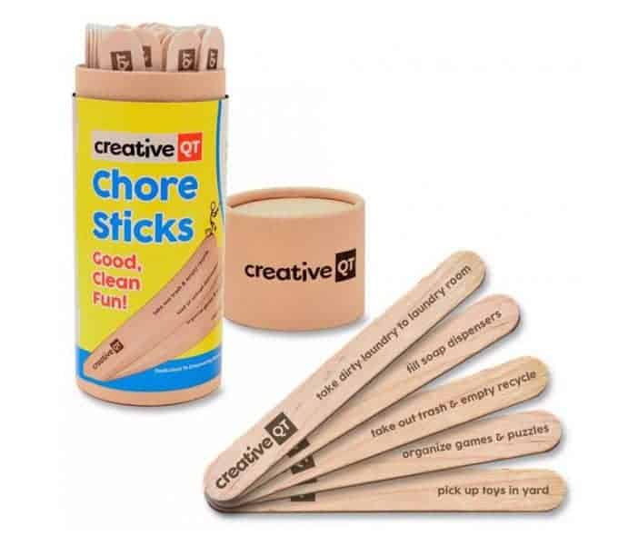 A container of Chore Sticks with a few sticks resting beside it.
