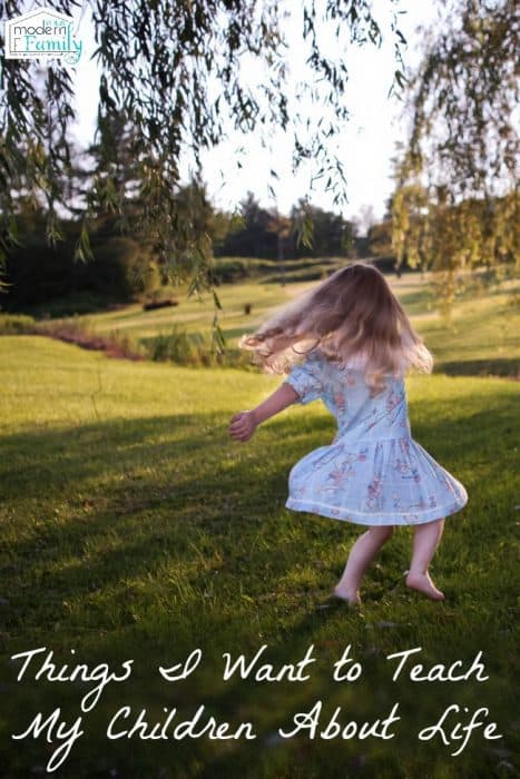 A little girl dancing in a grassy field with text below her.