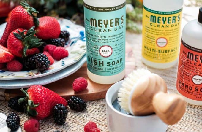 A close up of three bottles of Meyer\'s cleaning products next to a bowl of fruit.