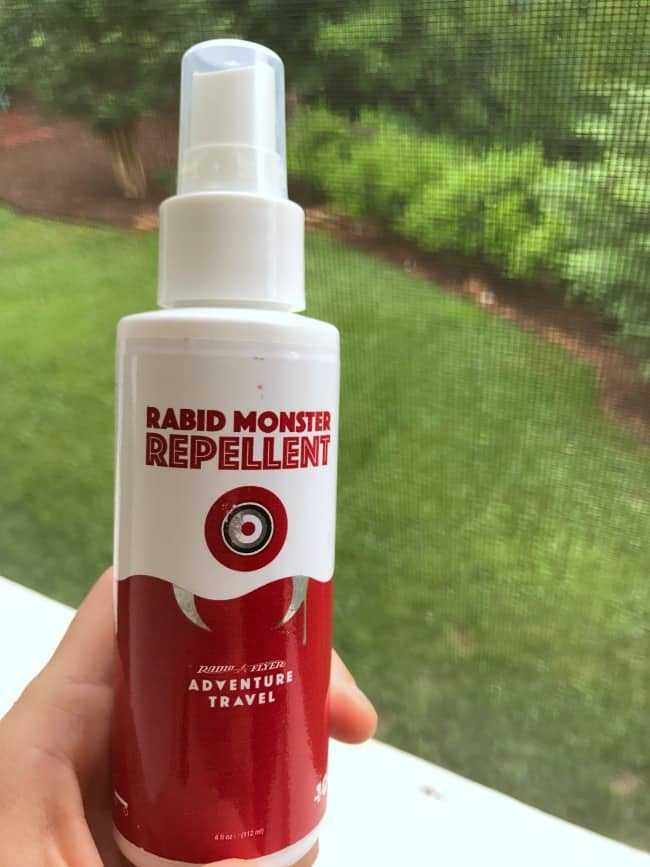 A person holding a spray bottle of Rabid Monster Repellent.
