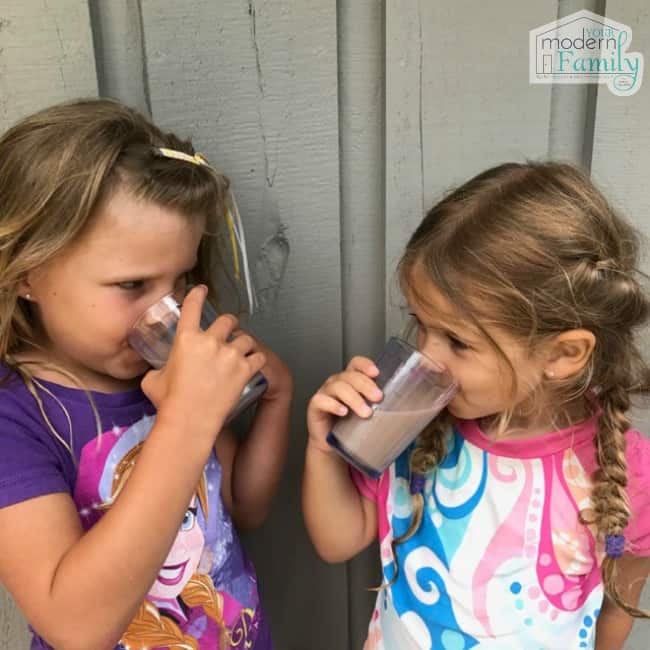 Two girls drinking banana chocolate milk.