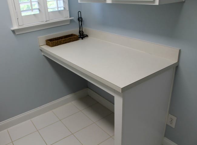 A white counter with a wicker basket on it.