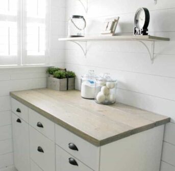 Laundry room with a counter and shelves above it.