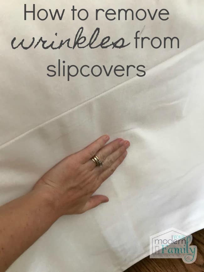 A close up of a white slip cover on a couch with a hand smoothing it and text above it.