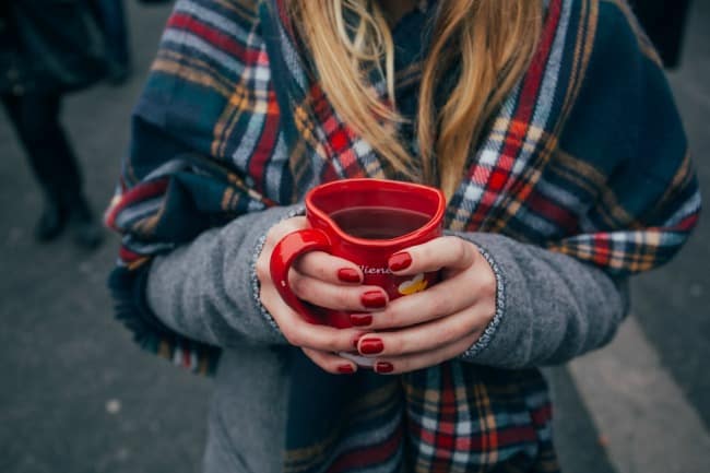 A women holding a cup of coffee.