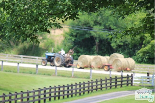 A tractor pulling a wagon of hay.