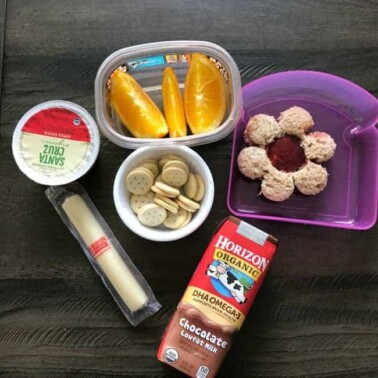 A variety of lunch food in containers on a table.