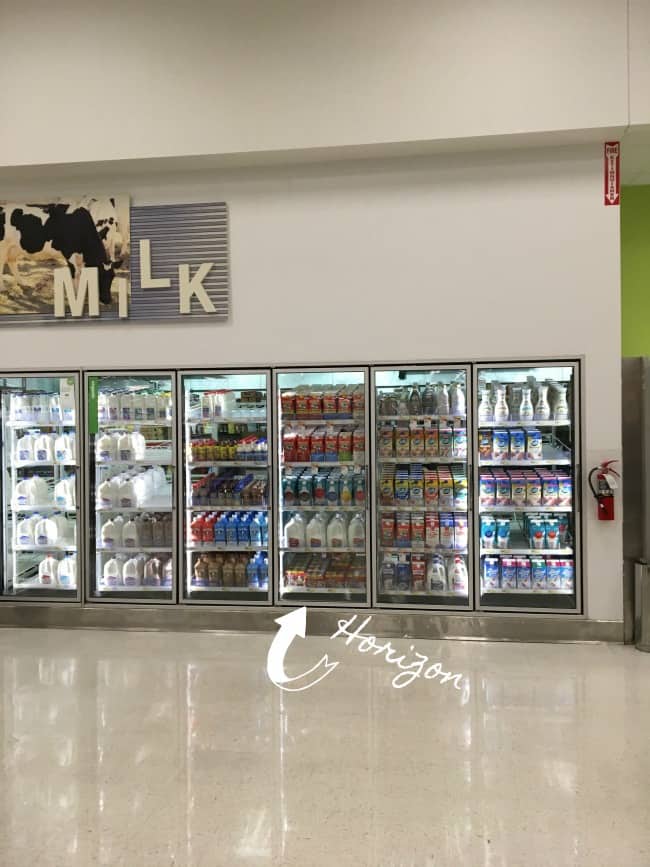 A glass display case in a store containing milk products.