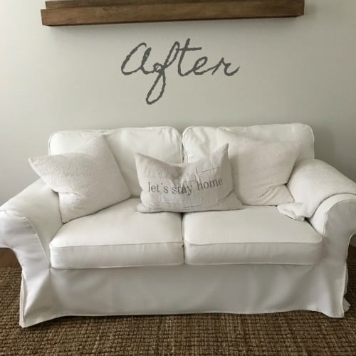 A  white sofa in a room with a text above it.