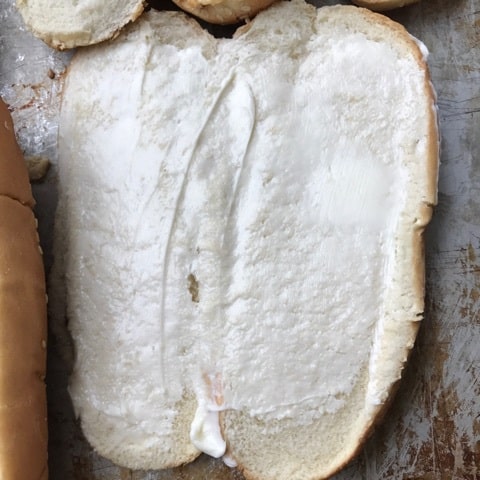 A sandwich roll cut open in half.
