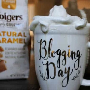 A bag of Folgers coffee and a cup of coffee with whipped cream on top.