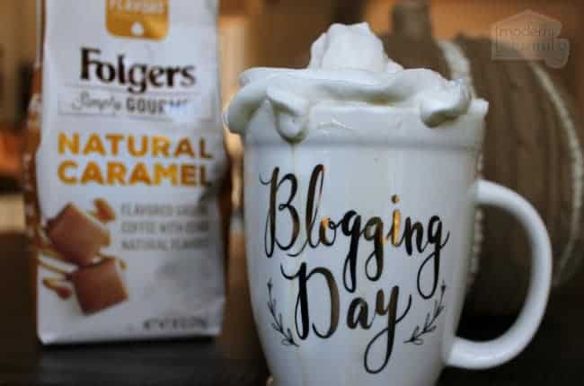 A bag of Folgers coffee and a cup of coffee with whipped cream on top.