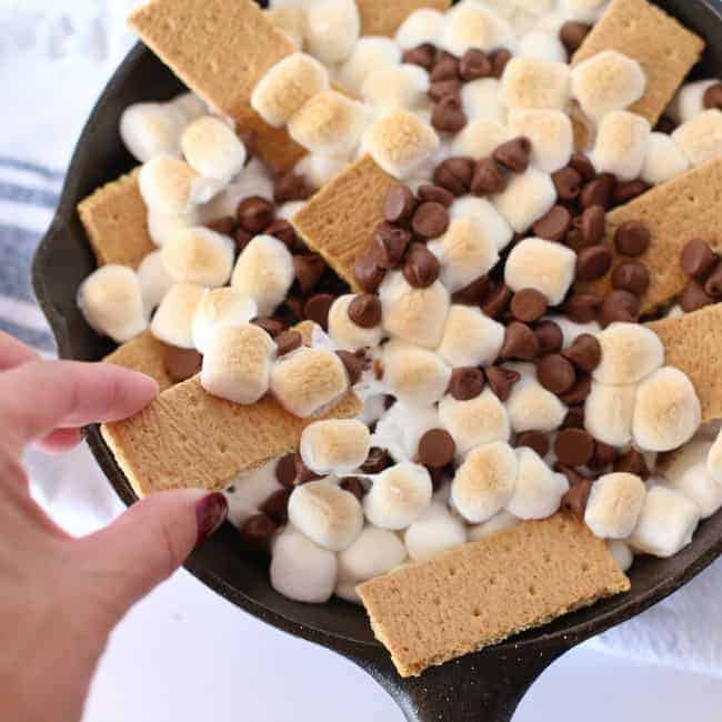 A black pan with graham crackers, marshmallows and chocolate chips.