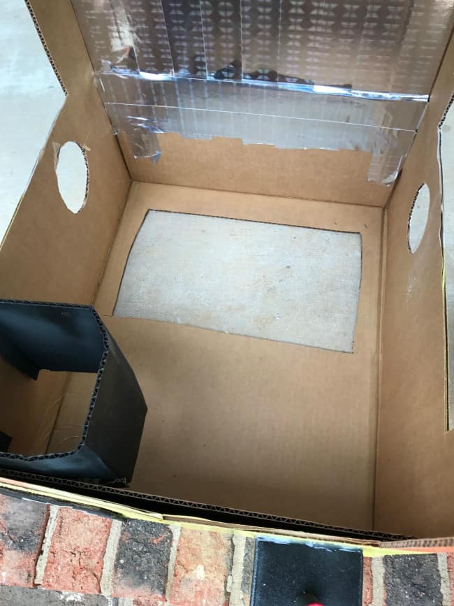 The inside of a cardboard box with the front cut out.