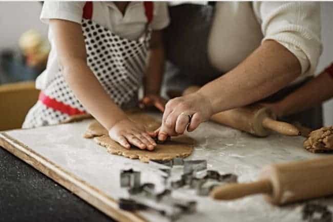 Close up of a woman and a child making Christmas cookies.