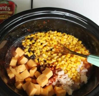 Crock pot filled with Cheesy Chicken Enchilada ingredients.