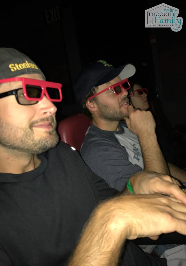 A man wearing 3D glasses in a movie theater.