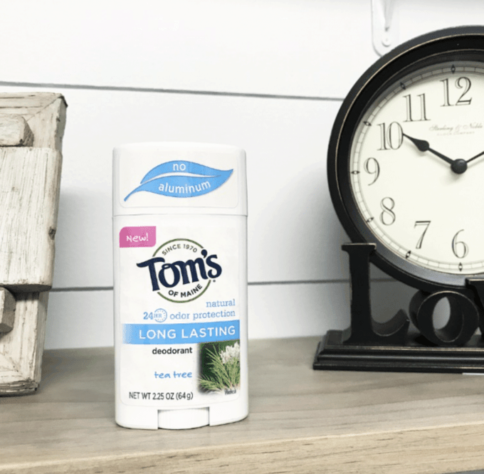 A container of Tom\'s deodorant standing beside a clock on the counter.