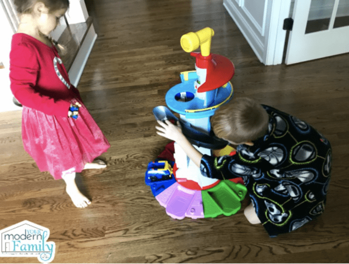 A little boy and girl playing together with a Paw Patrol Tower. 