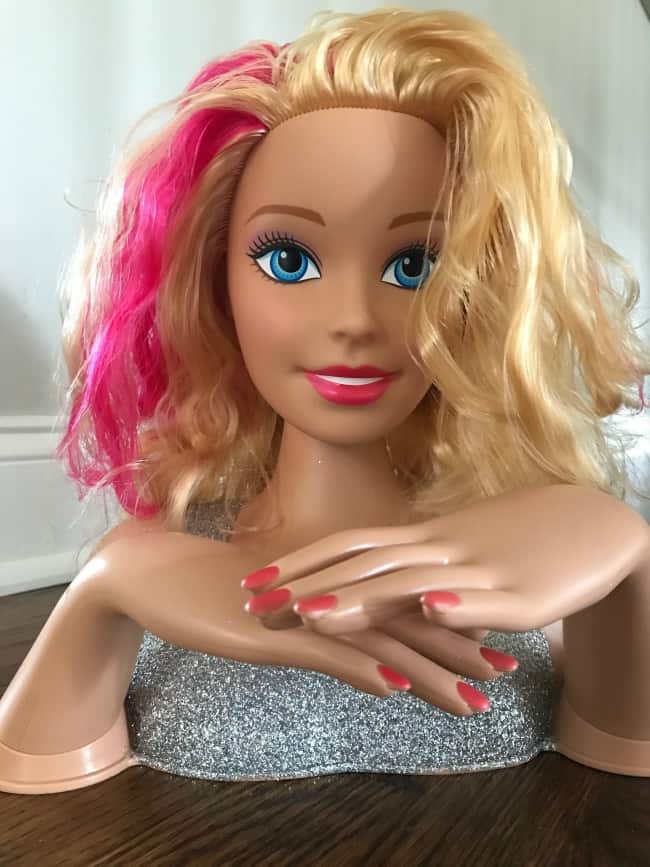 A close up of a Barbie Doll head and shoulders.