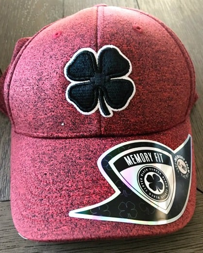 A red baseball cap with a black shamrock on it.