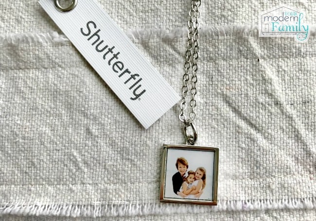 A close up of a necklace with a photo on the pendant.