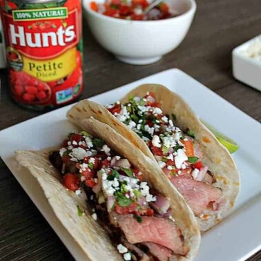 A plate of Tacos with a can of diced tomatoes beside it.