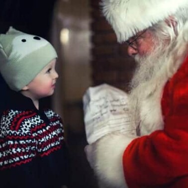 Santa Claus talking to a little boy.