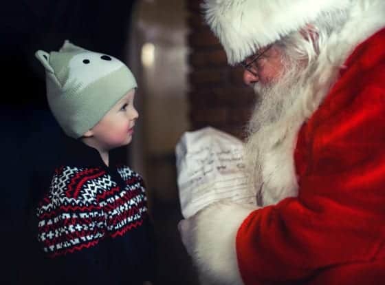 Weihnachtsmann im Gespräch mit einem kleinen Jungen.