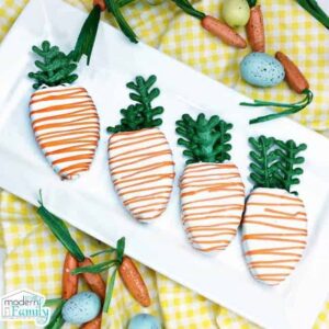 A white platter of carrot shaped decorated cookies.