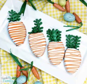 A white platter of carrot shaped decorated cookies.