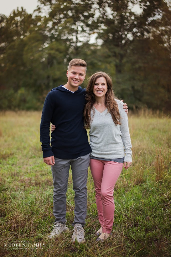 Two people standing in a field.
