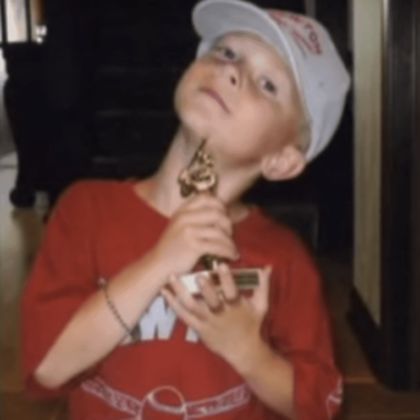 A little boy holding a trophy.
