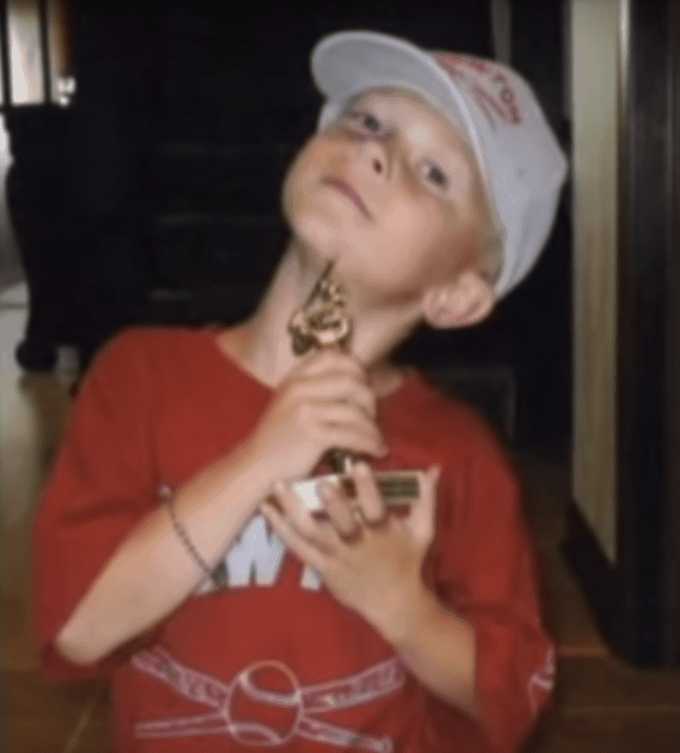 A little boy holding a trophy.